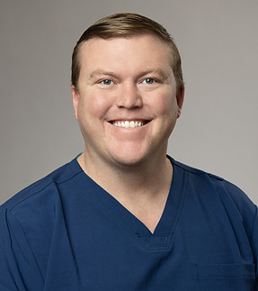 Man in blue scrubs smiling